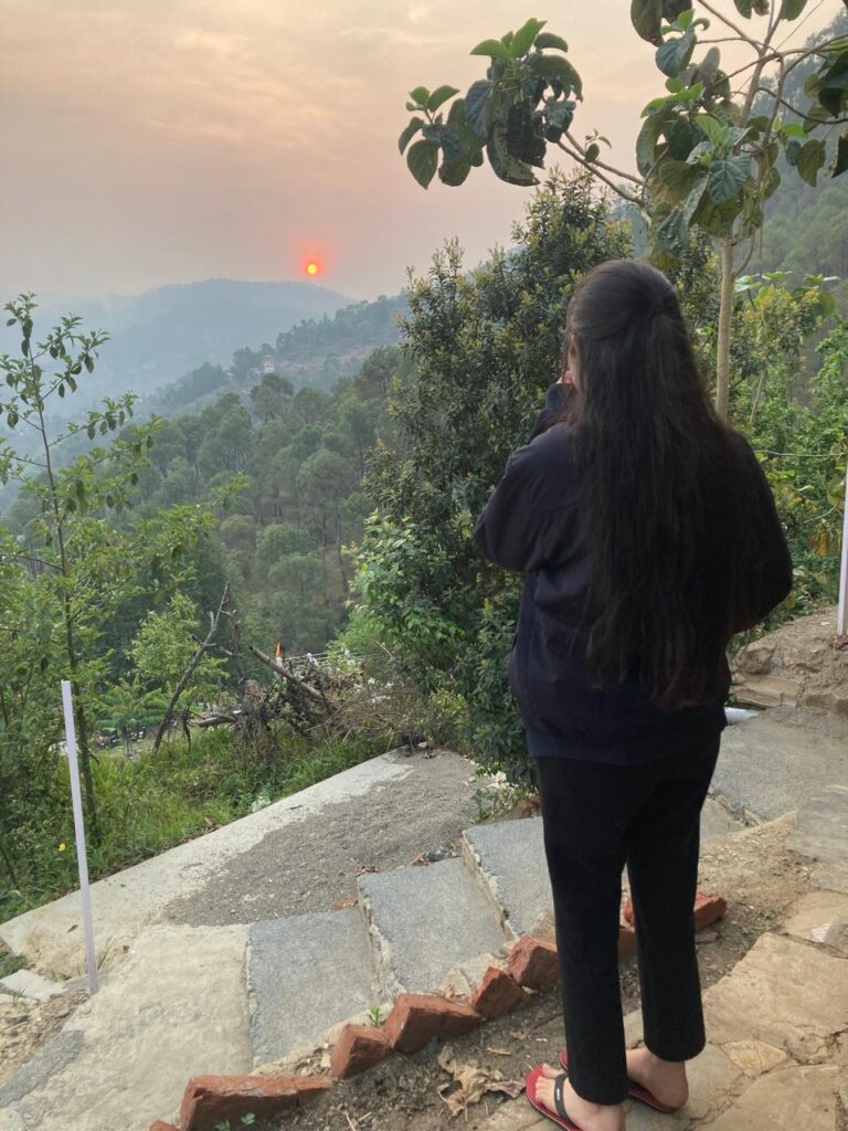 A girl standing in nature, admiring mountain views in Uttarakhand