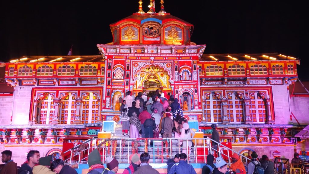 Devotees visiting the illuminated Badrinath Temple at night in Uttarakhand